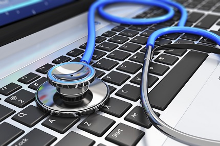 A blue stethoscope lying across a laptop keypad.